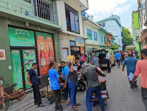 Street with motorcycle riders and workers Male in the Maldives