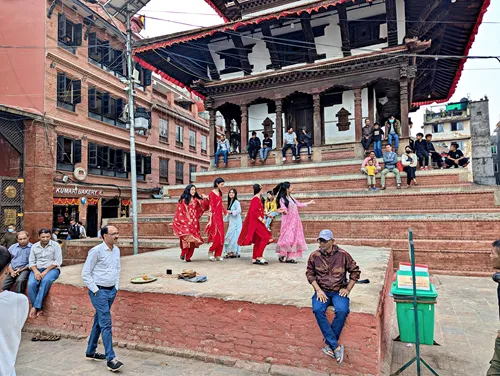 Teenage girls are playing music and dancing in Thamel Durbar Square in Kathmandu during the Tihar festival
