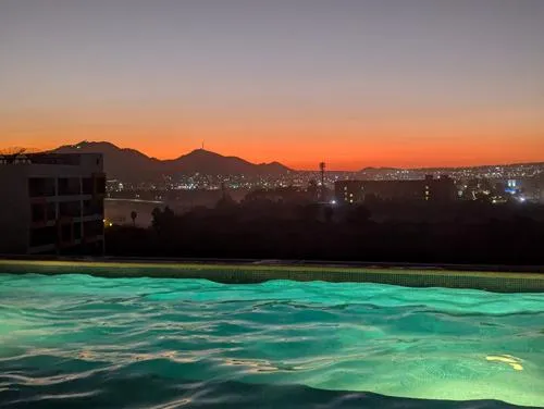 Colorful sunset over the roof-top swimming pool at Cabo Cottages Bahia Tezal in Cabo San Lucas, Mexico