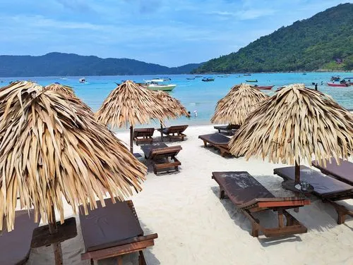 beach with straw sun umbrellas and loungers in front of BuBu Long Beach Resort on Pulau Perhentian Kecil (The Small Island)  in Malaysia