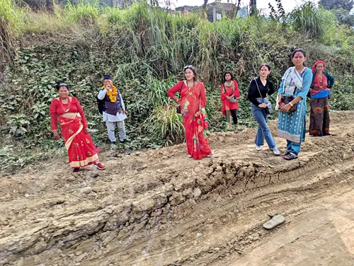 Well-dressed Nepali women waiting at the side of the road during a Drive from Kathmandu to Pokhara