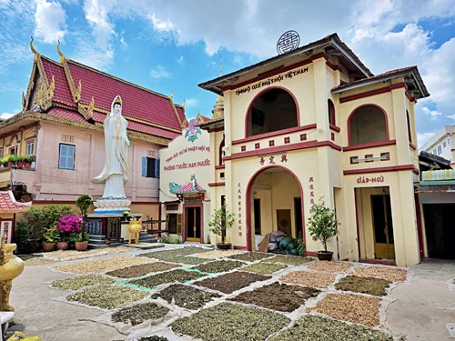 photo of the courtyard of Chùa Tịnh Độ Cư Sĩ Phật Hội Hưng Định Tự in Can Tho in Vietnam with drying herbs on the ground