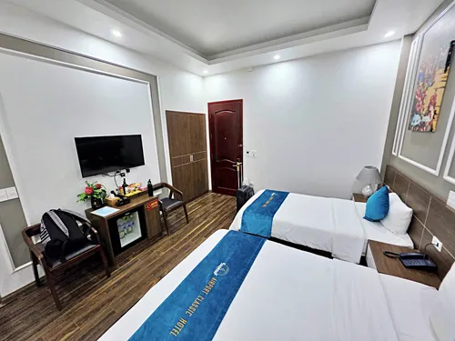 photo of the bedroom showing the beds, desk and chair at the Airport Classic Hotel & Travel in Hanoi in Vietnam