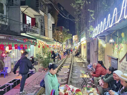 Train tracks with lots of spectators at Hanoi Train Street in Hanoi in Vietnam shortly vefore the train comes