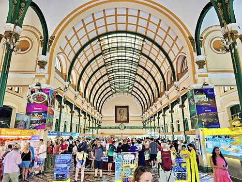 photo of the inside of Ho Chi Minh Central Post Office in Ho Chin Minh City, Vietnam, showing its grand design with the wide arch-domed ceiling