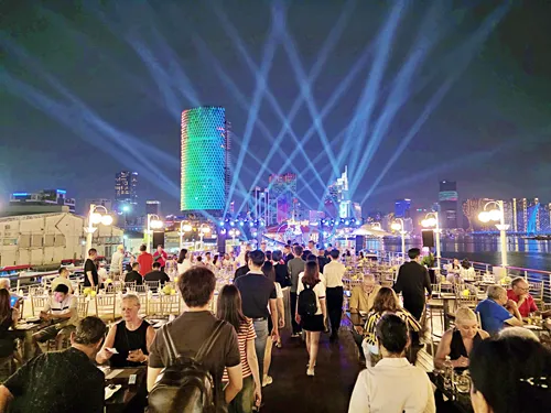 Beautifully illuminated Ho Chi Minh City skyline at night during a Saigon River Dinner Cruise in Vietnam