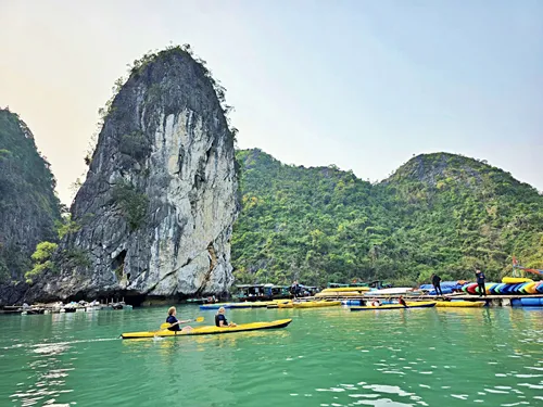 Kayaks in front of a karst mountain in Lan Ha Bay in Vietnam